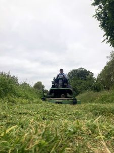 Burgess Park gardener on a ride on mower.