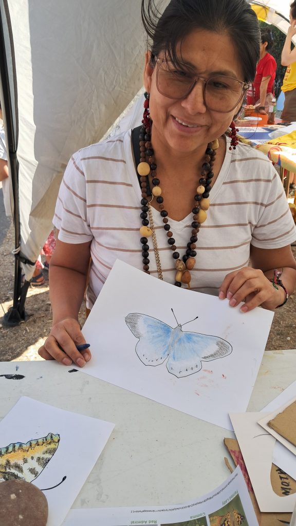 Butterfly art with stencils for Burgess Park species; adult hold completed butterfly picture.
